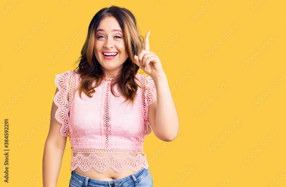 Young beautiful caucasian woman wearing casual clothes pointing finger up with successful idea. exited and happy. number one. Young beautiful caucasian woman wearing casual clothes pointing finger up with successful idea. exited and happy. number one.