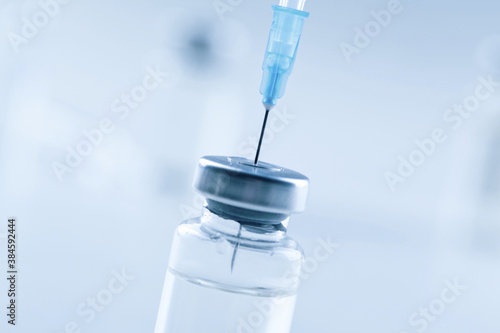Medical syringe with a needle and a bollte with vaccine.