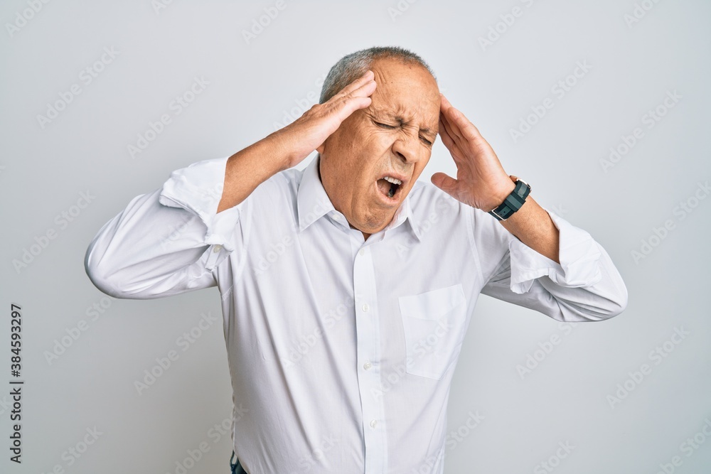 Handsome senior man wearing casual white shirt with hand on head, headache because stress. suffering migraine. Handsome senior man wearing casual white shirt with hand on head, headache because stress. suffering migraine.