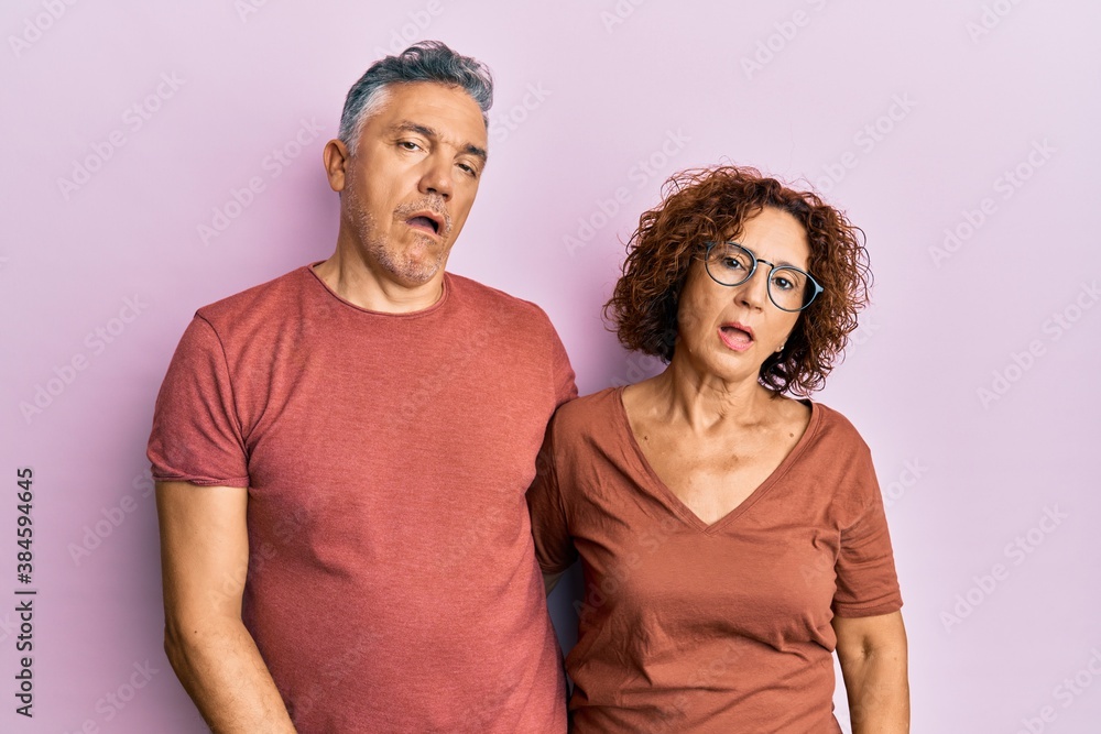 Beautiful middle age couple together wearing casual clothes looking sleepy and tired, exhausted for fatigue and hangover, lazy eyes in the morning. Beautiful middle age couple together wearing casual clothes looking sleepy and tired, exhausted for fatigue and hangover, lazy eyes in the morning.