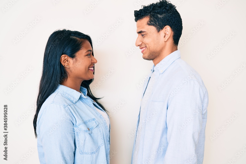 Beautiful latin young couple wearing casual clothes looking to side, relax profile pose with natural face with confident smile. Beautiful latin young couple wearing casual clothes looking to side, relax profile pose with natural face with confident smile.