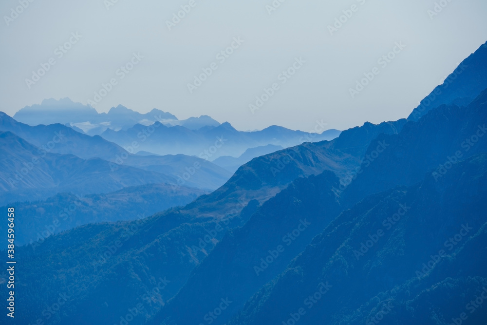 blurred abstract natural background with Caucasus Mountains in a morning blue mist