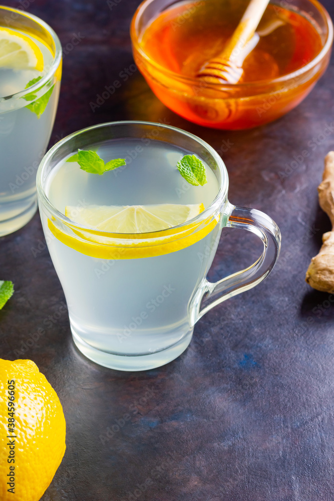 Ginger tea with lemon on a dark background. Two cups of ginger tea and ingredients for its preparation Ginger tea with lemon on a dark background. Two cups of ginger tea and ingredients for its preparation