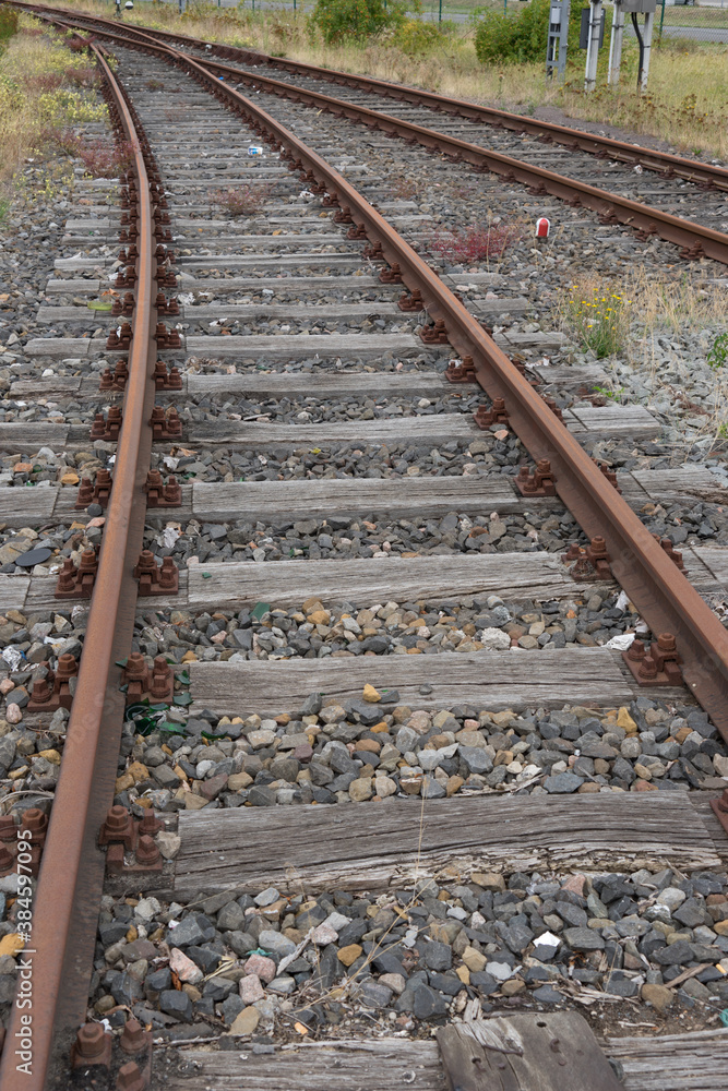 Background of old rusty curved rails in a gravel bedding on an abandoned factory premises Background of old rusty curved rails in a gravel bedding on an abandoned factory premises