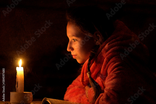 girl in front of a candle with a book