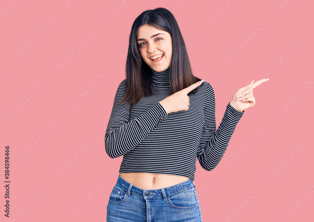 Young beautiful girl wearing striped t shirt smiling and looking at the camera pointing with two hands and fingers to the side. Young beautiful girl wearing striped t shirt smiling and looking at the camera pointing with two hands and fingers to the side.