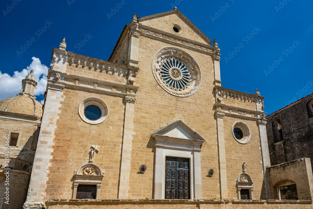 Gravina in Puglia, Italy. The facade of the cathedral. The large central rose window and three portals. The large main door decorated with bas-reliefs and surmounted by a marble tympanum.