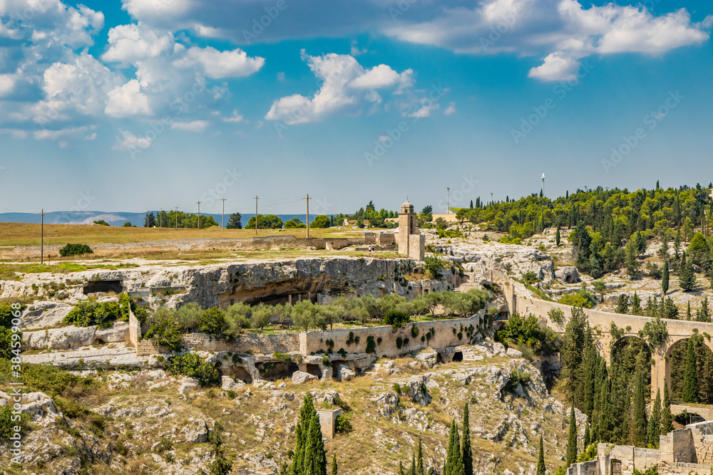 Gravina in Puglia, Italy. The stone bridge, ancient aqueduct and viaduct, over the Gravina stream. The Madonna della Stella Sanctuary, with its bell tower and the ancient cave church.