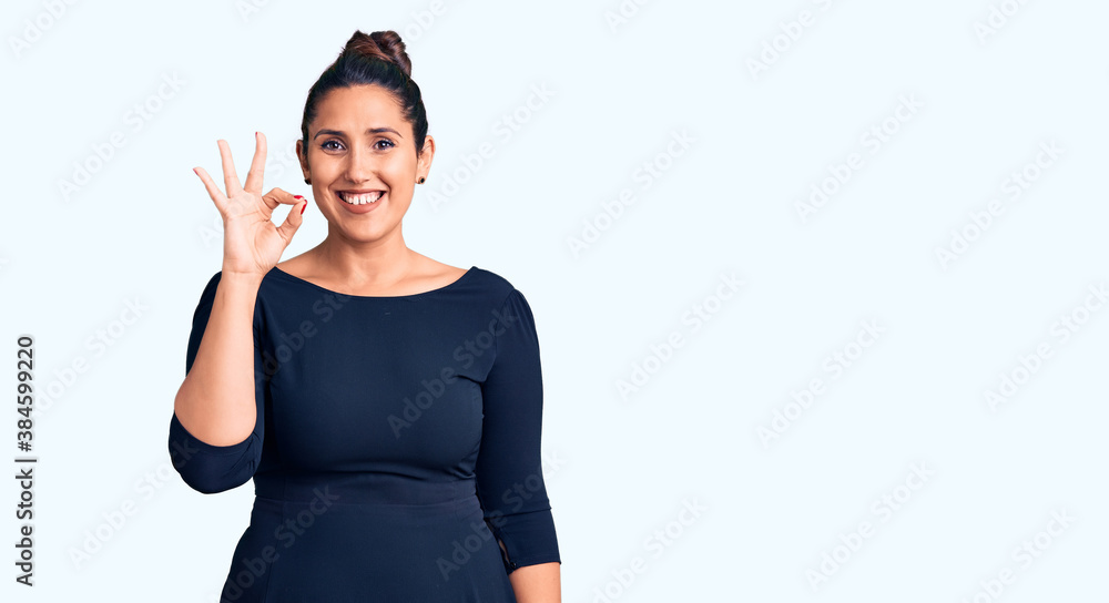 Young beautiful brunette woman wearing casual dress smiling positive doing ok sign with hand and fingers. successful expression. Young beautiful brunette woman wearing casual dress smiling positive doing ok sign with hand and fingers. successful expression.