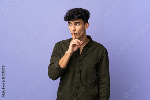 Young Argentinian man isolated on background showing a sign of silence gesture putting finger in mouth
