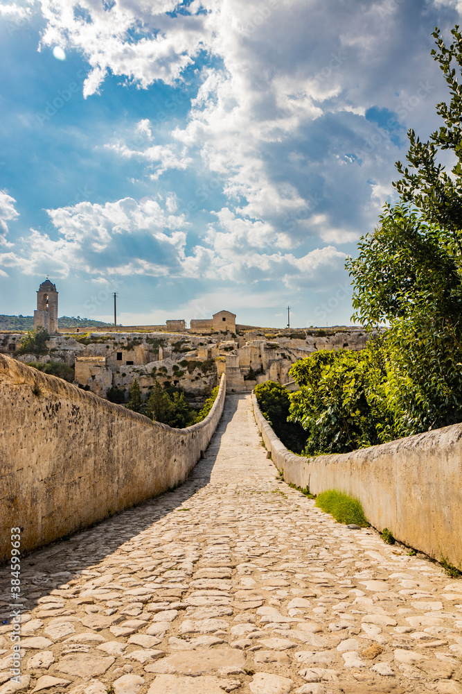 Gravina in Puglia, Italy. The stone bridge, ancient aqueduct and viaduct, over the Gravina stream. The Madonna della Stella Sanctuary, with its bell tower and the ancient cave church. Gravina in Puglia, Italy. The stone bridge, ancient aqueduct and viaduct, over the Gravina stream. The Madonna della Stella Sanctuary, with its bell tower and the ancient cave church.
