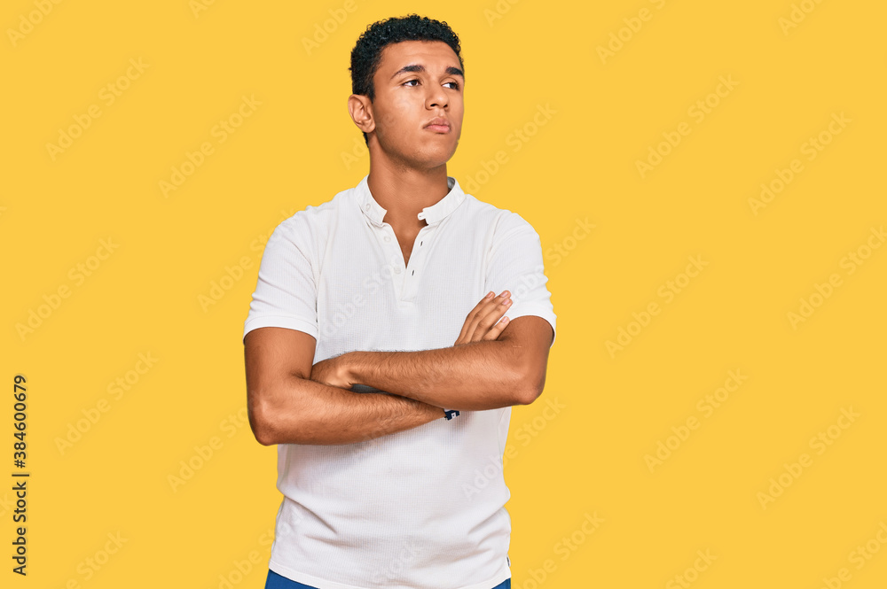 Young arab man wearing casual clothes looking to the side with arms crossed convinced and confident Young arab man wearing casual clothes looking to the side with arms crossed convinced and confident