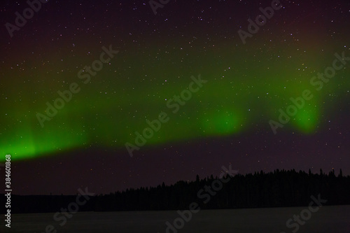 View of the aurora borealis. Polar lights in the night starry sky over the lake. © lexuss