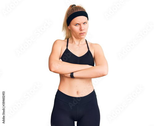 Young beautiful blonde woman wearing sportswear skeptic and nervous, disapproving expression on face with crossed arms. negative person.