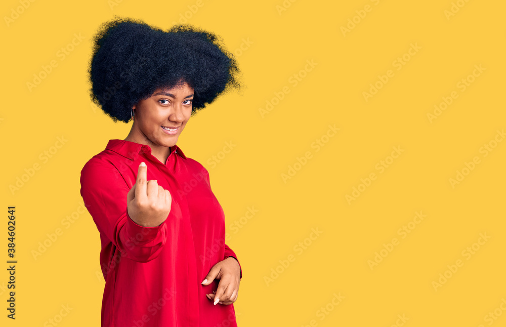 Young african american girl wearing casual clothes beckoning come here gesture with hand inviting welcoming happy and smiling Young african american girl wearing casual clothes beckoning come here gesture with hand inviting welcoming happy and smiling
