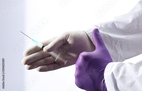 doctors offer vaccine with kind gesture, syringe and purple glove