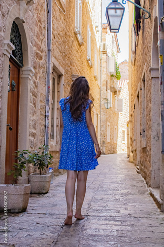 A girl in a blue dress walks through the narrow streets of the old city. Montenegro. Travels © Лилия Люцко