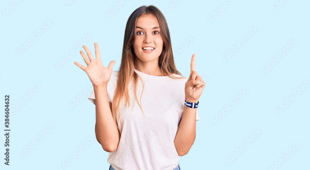 Beautiful caucasian woman wearing casual white tshirt showing and pointing up with fingers number six while smiling confident and happy. Beautiful caucasian woman wearing casual white tshirt showing and pointing up with fingers number six while smiling confident and happy.