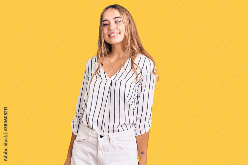 Young beautiful blonde woman wearing casual clothes looking positive and happy standing and smiling with a confident smile showing teeth Young beautiful blonde woman wearing casual clothes looking positive and happy standing and smiling with a confident smile showing teeth