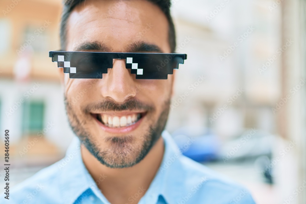 Young hispanic man smiling happy wearing funny sunglasses standing at street of city. Young hispanic man smiling happy wearing funny sunglasses standing at street of city.