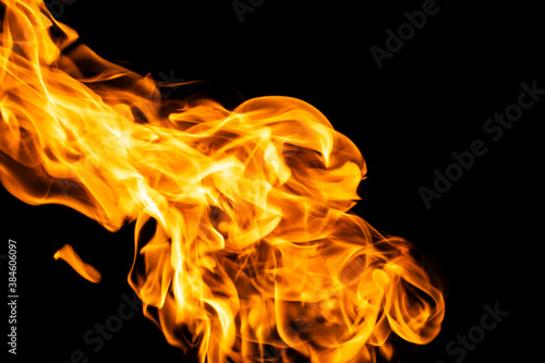 Fire flames on black background isolated. Burning gas or gasoline burns with fire and flames. Flaming burning sparks close-up, fire patterns. Infernal glow of fire in the dark with copy-space