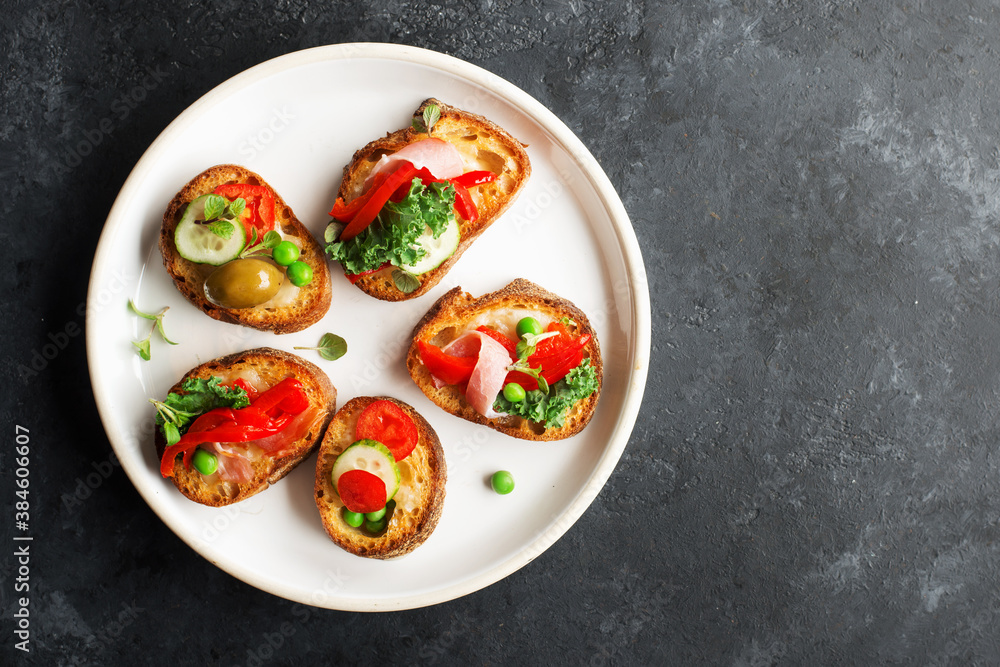 Finger food. Appetizing crostini with baked capsicum, green peas, bacon, kale and lettuce as a festive snack. Top view, Finger food. Appetizing crostini with baked capsicum, green peas, bacon, kale and lettuce as a festive snack. Top view,