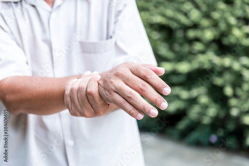 Patients elderly wrist pain hands, due to a nervous system illness and paralysis, On blur background, to health care concept. photo