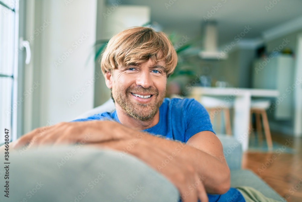 Fototapeta premium Middle age handsome caucasian man relaxing sitting on the sofa at home