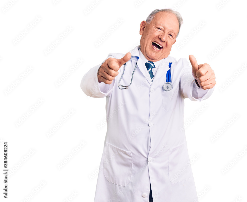 Senior handsome grey-haired man wearing doctor coat and stethoscope approving doing positive gesture with hand, thumbs up smiling and happy for success. winner gesture.
