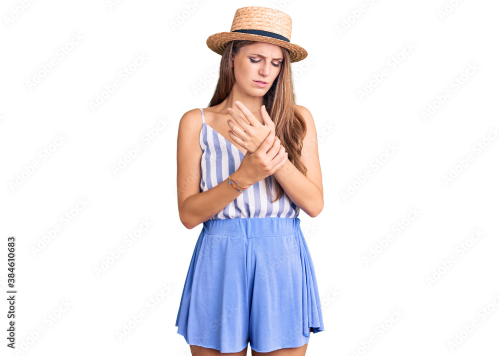 Young beautiful blonde woman wearing summer hat suffering pain on hands and fingers, arthritis inflammation Young beautiful blonde woman wearing summer hat suffering pain on hands and fingers, arthritis inflammation
