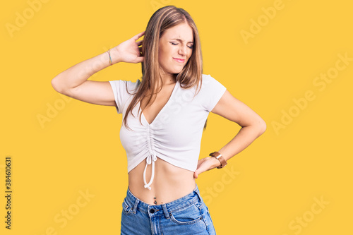 Young beautiful blonde woman wearing casual white tshirt suffering of neck ache injury, touching neck with hand, muscular pain © Krakenimages.com