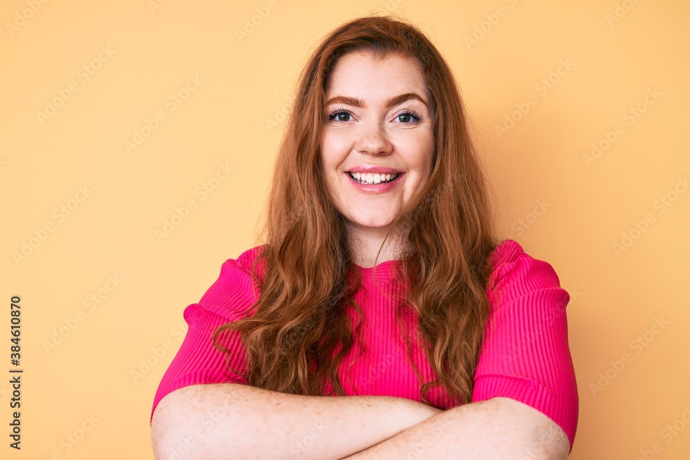 Young redhead woman wearing casual clothes happy face smiling with crossed arms looking at the camera. positive person. Young redhead woman wearing casual clothes happy face smiling with crossed arms looking at the camera. positive person.