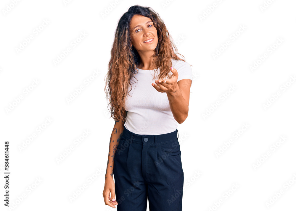 Young hispanic woman with tattoo wearing casual white tshirt smiling friendly offering handshake as greeting and welcoming. successful business. Young hispanic woman with tattoo wearing casual white tshirt smiling friendly offering handshake as greeting and welcoming. successful business.