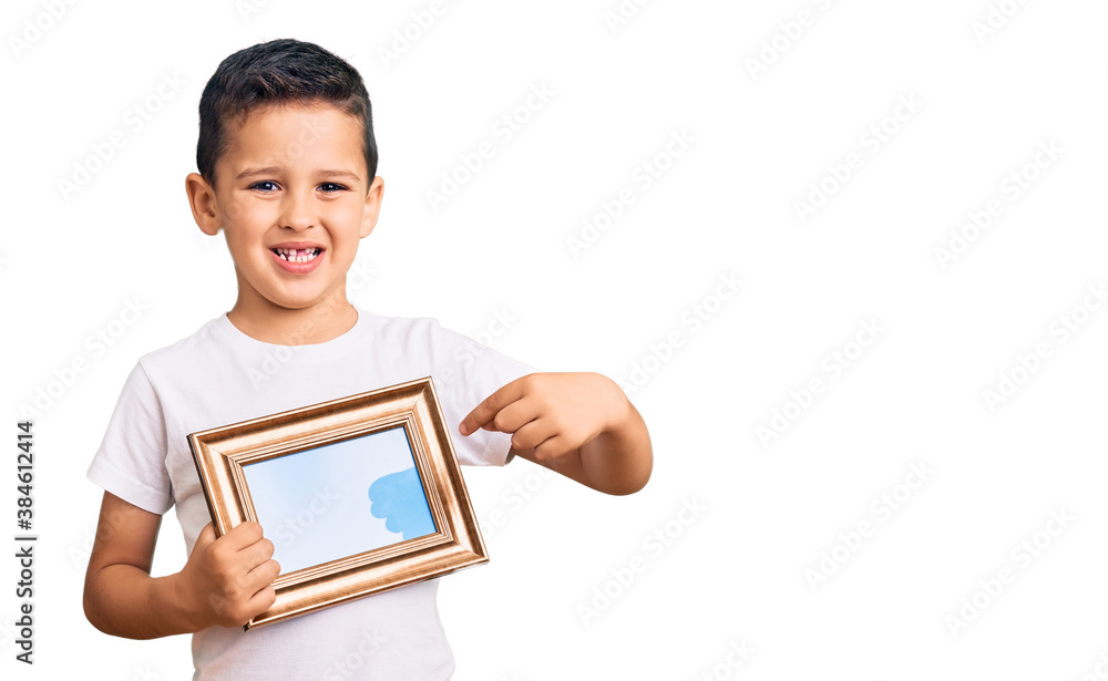 Little cute boy kid holding empty frame smiling happy pointing with hand and finger Little cute boy kid holding empty frame smiling happy pointing with hand and finger