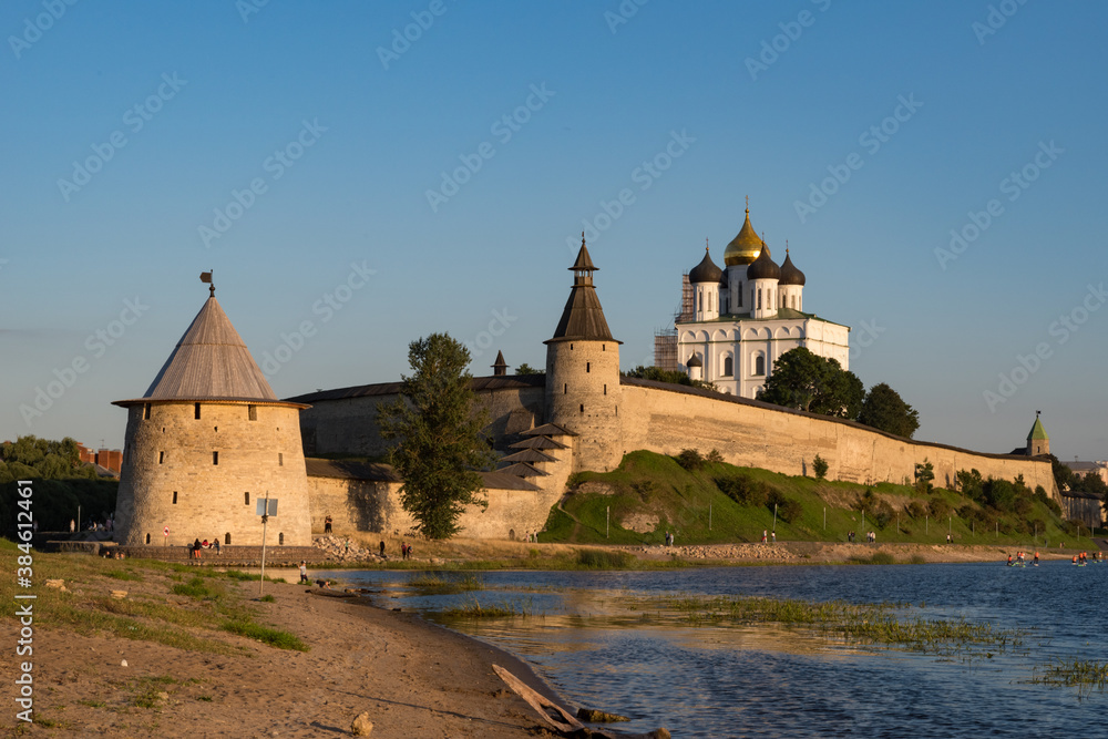 Pskov Kremlin view from river Pskova creek. Towers, wall and Trinity cathedral on background.