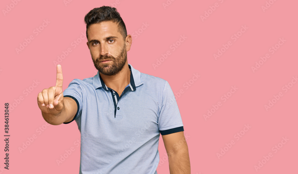 Handsome man with beard wearing casual clothes pointing with finger up and angry expression, showing no gesture Handsome man with beard wearing casual clothes pointing with finger up and angry expression, showing no gesture