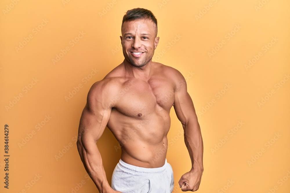 Fototapeta premium Handsome bodybuldier man posing sexy showing muscle, shirtless torso showing pectorals and sixpack
