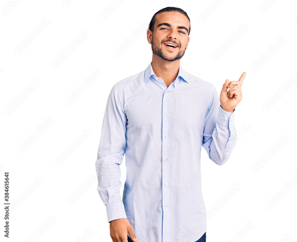 Young handsome man wearing business clothes with a big smile on face, pointing with hand finger to the side looking at the camera. Young handsome man wearing business clothes with a big smile on face, pointing with hand finger to the side looking at the camera.