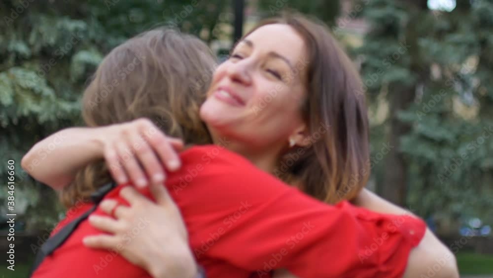 Two happy young girls are hugging each other, females embracing, laughing and excited. Woman friendship concept