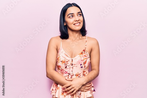 Young beautiful latin woman wearing casual clothes looking away to side with smile on face, natural expression. laughing confident. © Krakenimages.com