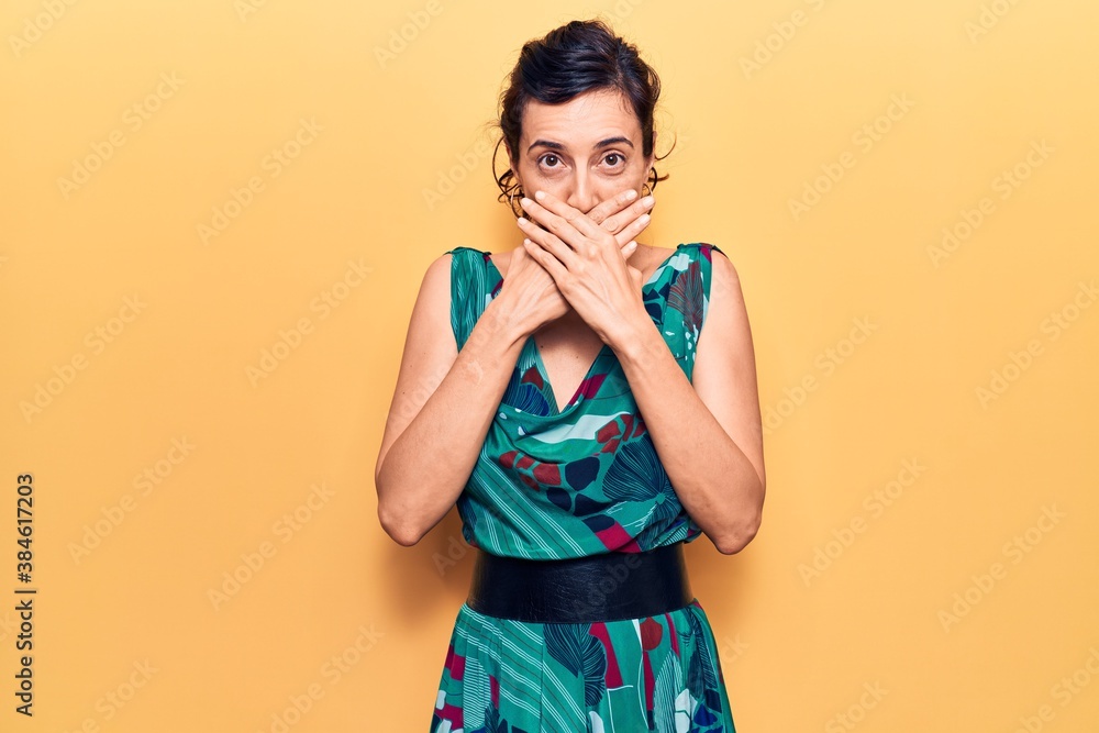 Young beautiful hispanic woman wearing casual dress shocked covering mouth with hands for mistake. secret concept. Young beautiful hispanic woman wearing casual dress shocked covering mouth with hands for mistake. secret concept.