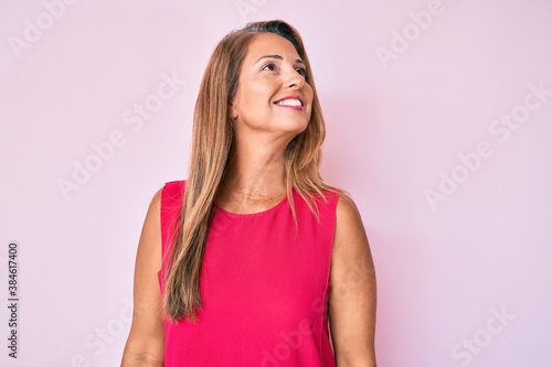 Middle age hispanic woman wearing casual clothes looking to side, relax profile pose with natural face and confident smile.