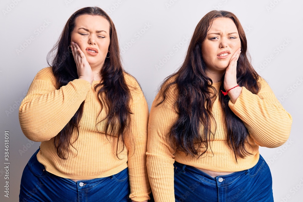 Young plus size twins wearing casual clothes touching mouth with hand with painful expression because of toothache or dental illness on teeth. dentist Young plus size twins wearing casual clothes touching mouth with hand with painful expression because of toothache or dental illness on teeth. dentist