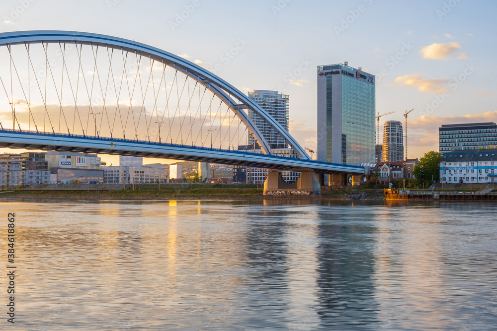 2020: Long exposure Apollo bridge over river Danube in Bratislava, Slovakia. Sunset, golden hour, dramatic skies. High rise buildings, travel destination