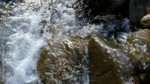 Mountain stream. The shine of the sun on a wet stone in the evening golden hour. Kvasy, Zakarpattia region, Ukraine. photo