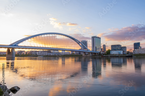 2020: Long exposure Apollo bridge over river Danube in Bratislava, Slovakia. Sunset, golden hour, dramatic skies. High rise buildings, travel destination