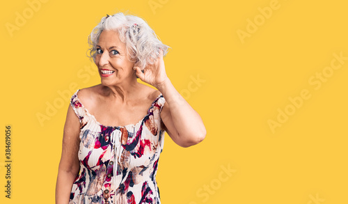 Senior grey-haired woman wearing casual clothes smiling with hand over ear listening an hearing to rumor or gossip. deafness concept.