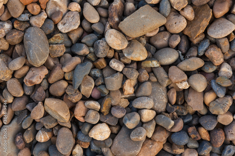 Colorful beach stone background. River pebble close-ups. View of pebbles from above Colorful beach stone background. River pebble close-ups. View of pebbles from above