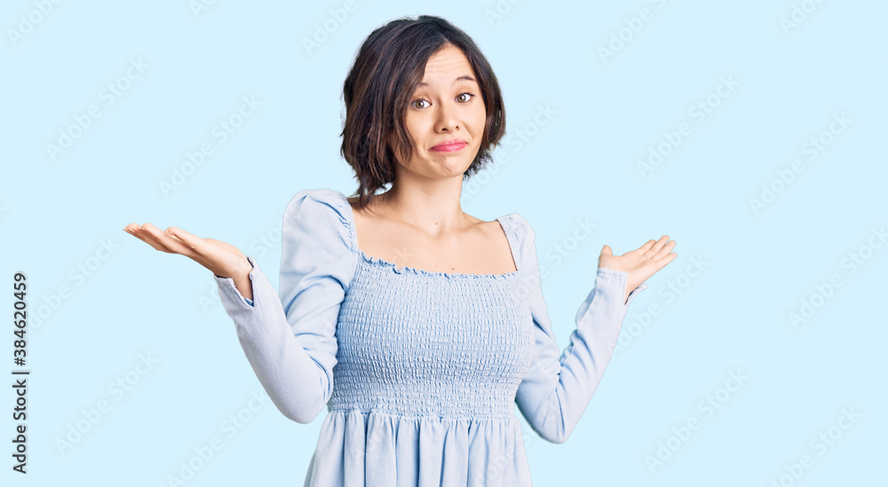 Young beautiful girl wearing casual clothes clueless and confused expression with arms and hands raised. doubt concept. Young beautiful girl wearing casual clothes clueless and confused expression with arms and hands raised. doubt concept.
