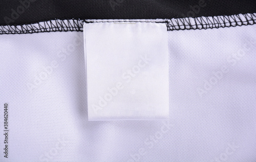White blank clothing tag label on shirt fabric texture background